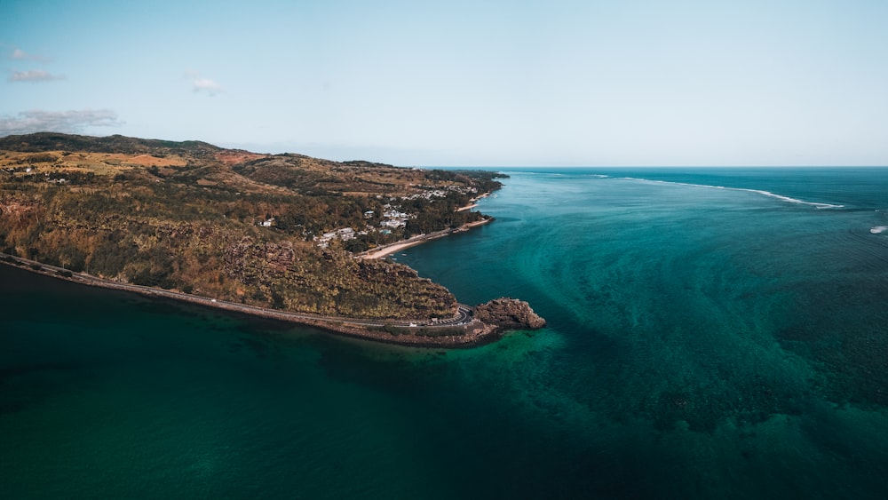 green and brown island in the middle of blue sea during daytime