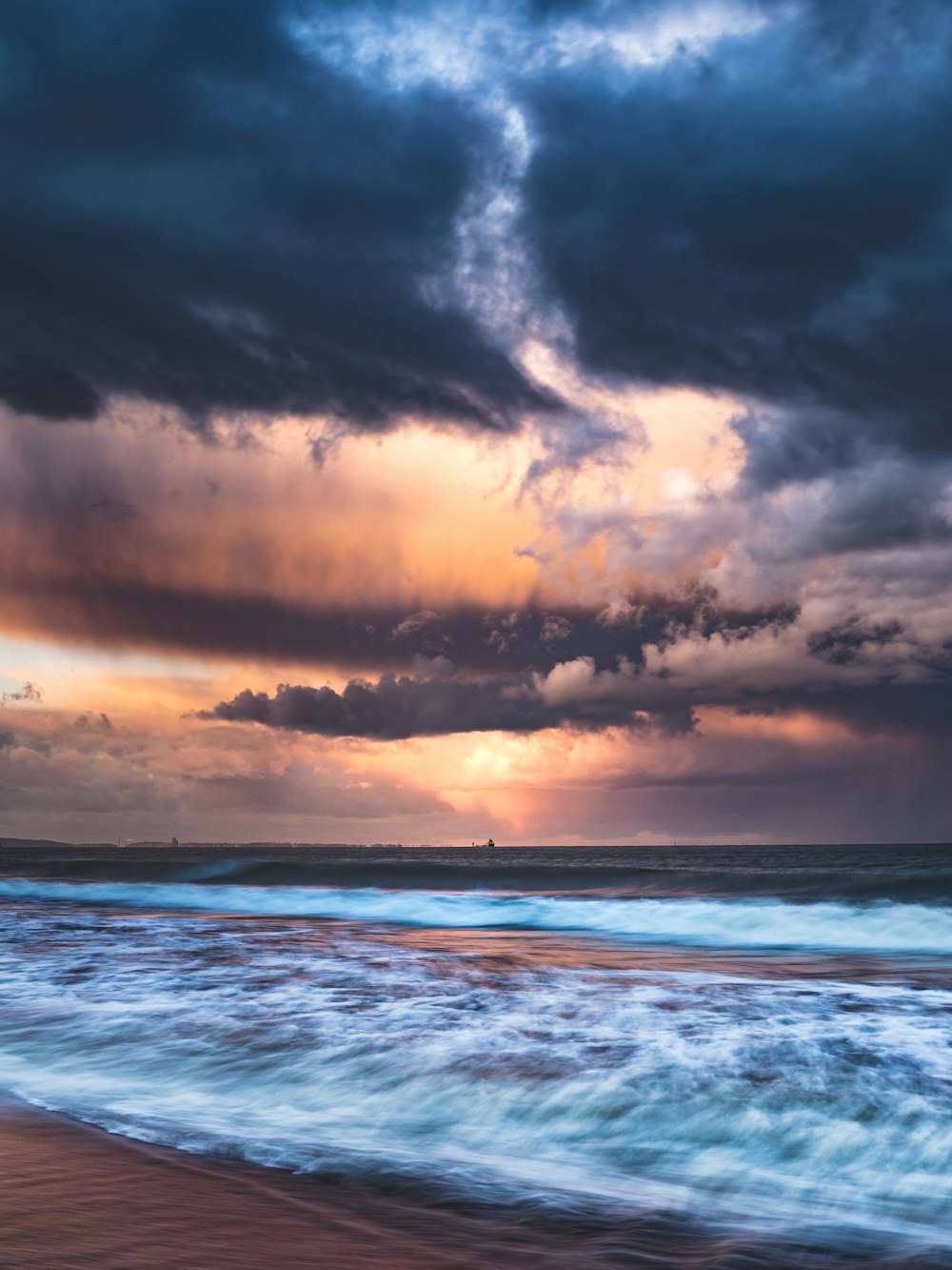 ondas do oceano sob o céu nublado durante o dia