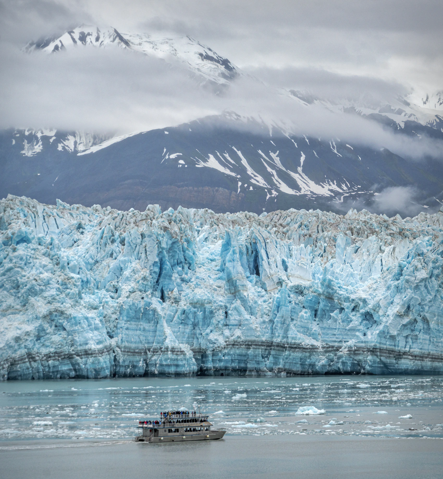 A small vessel crossing icy water near Hubbard Glacier in Alaska