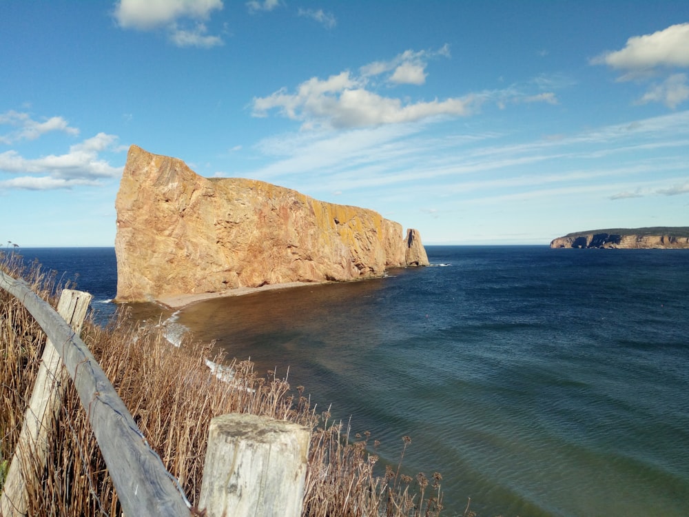 brown rock formation on blue sea under blue sky during daytime