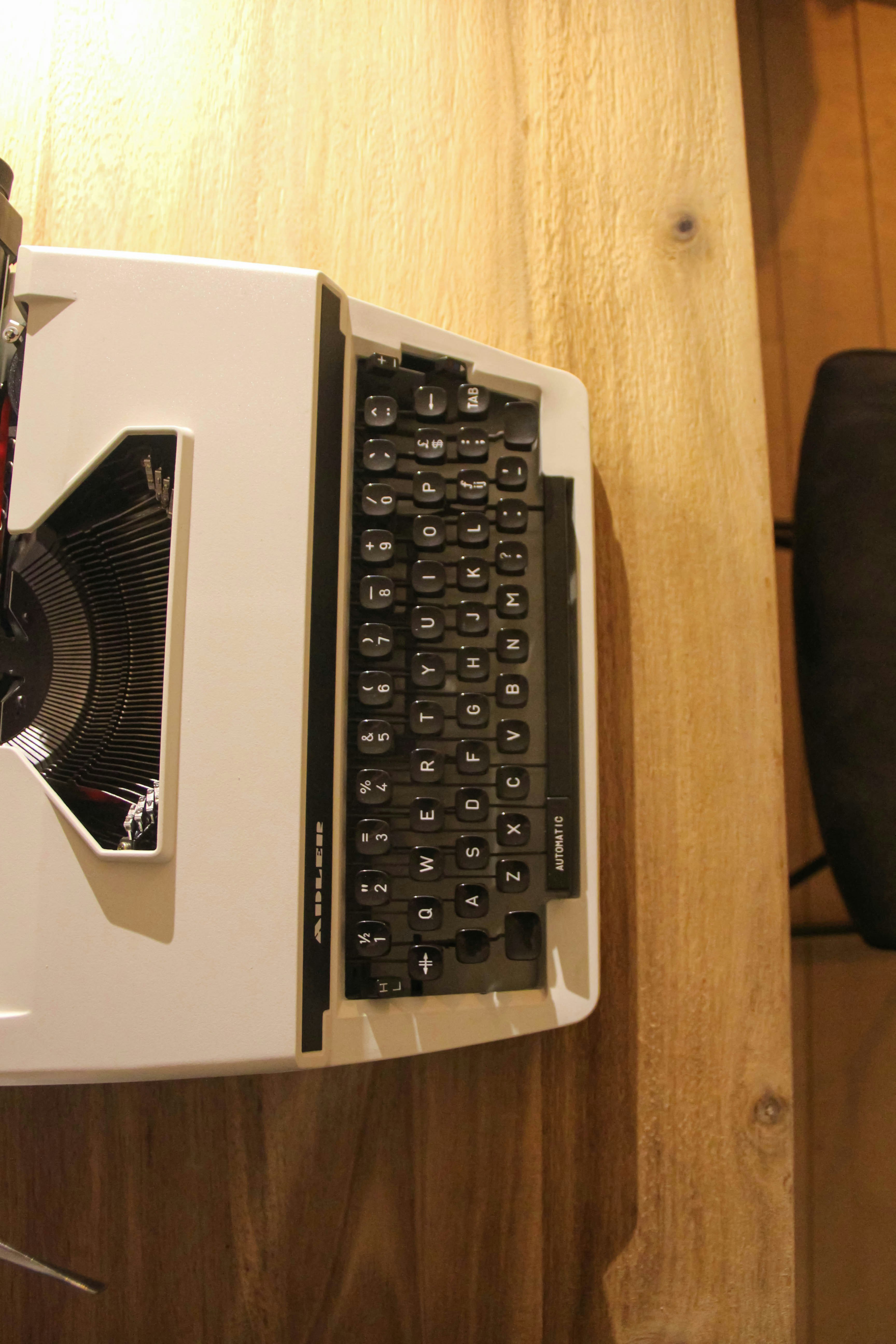 black and silver computer keyboard on brown wooden desk