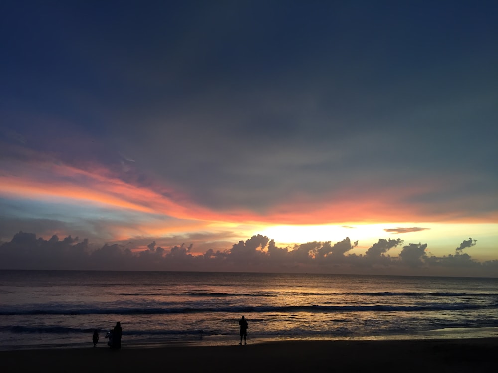 silhouette of people on beach during sunset