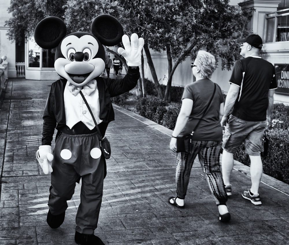 grayscale photo of man in black shirt and pants holding camera