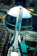 Exterior shot of a sleek, mobile capsule hotel unit parked in an urban setting.