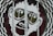 A large graphic of a stylized face with prominent oversized glasses displaying the word 'GO'. The image is part of a glass door with a surrounding black and white checkered circular pattern. The facial features are minimalist and cartoon-like, presenting a playful and eye-catching design.