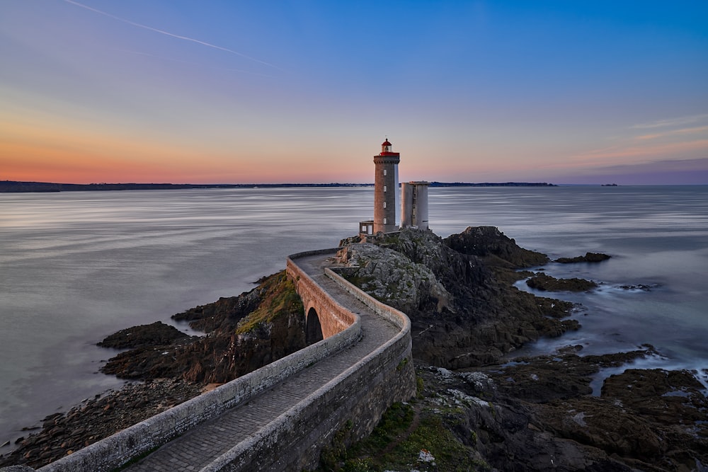 white and brown concrete lighthouse near sea during daytime