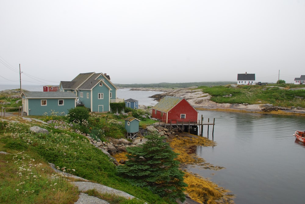 white and red house beside body of water during daytime