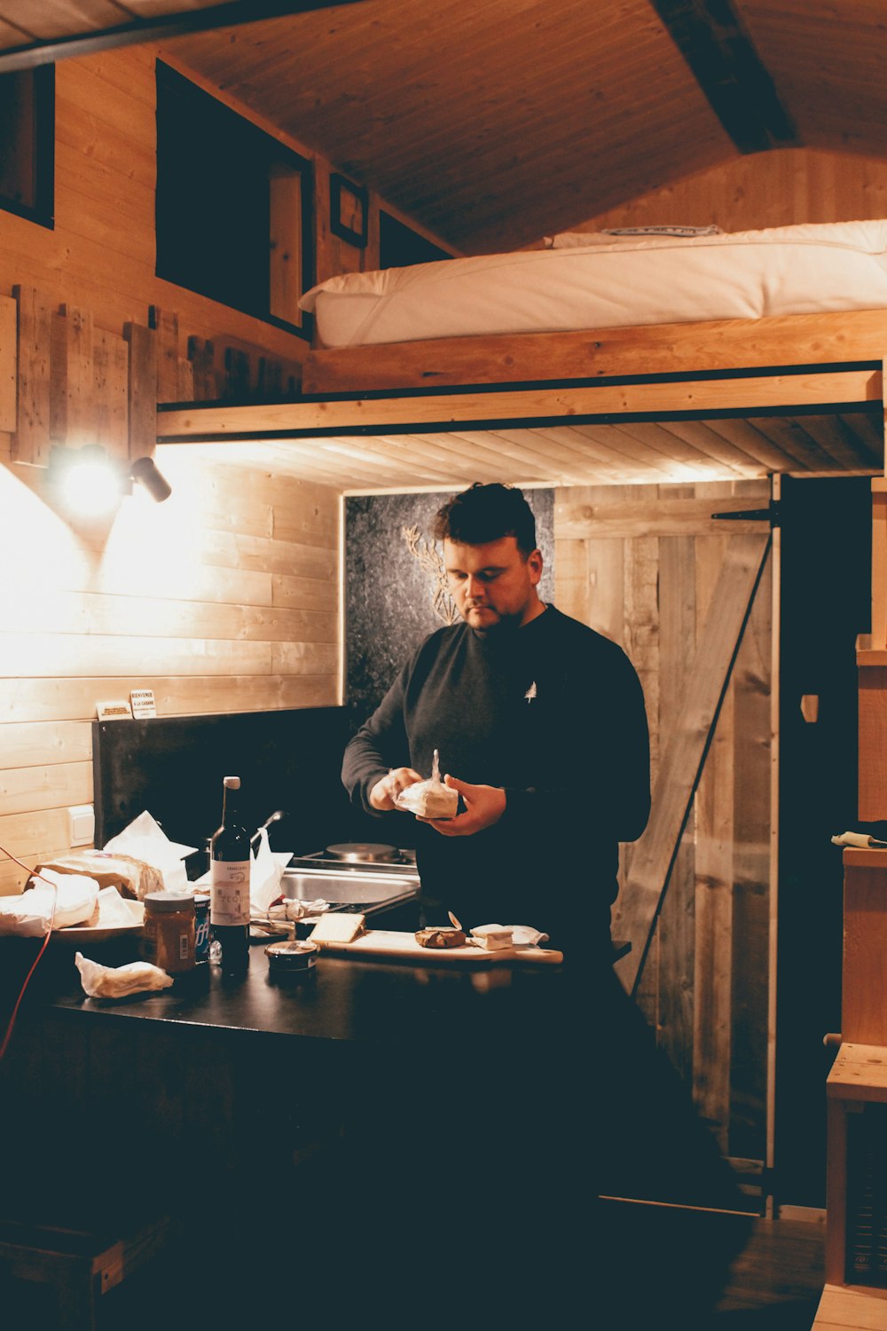 man in black dress shirt standing in front of table