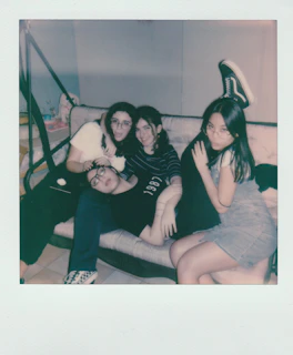 A playful group selfie with laughter bubbling among friends in a cozy living room.