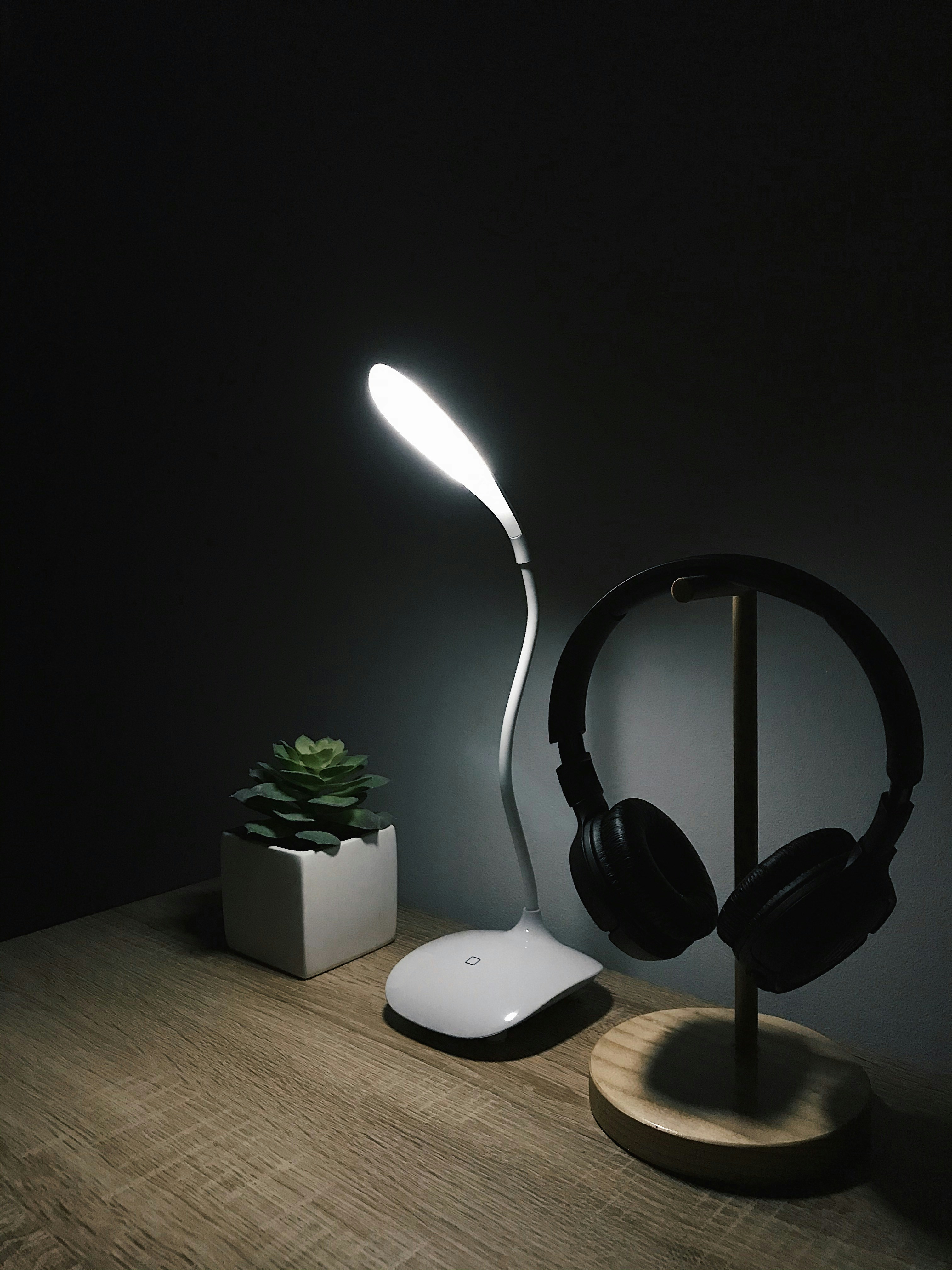 갈색 나무 테이블에 검은 무선 헤드폰