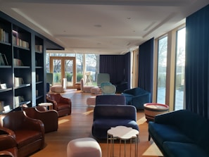 Shared lounge space with comfy chairs and bookshelves