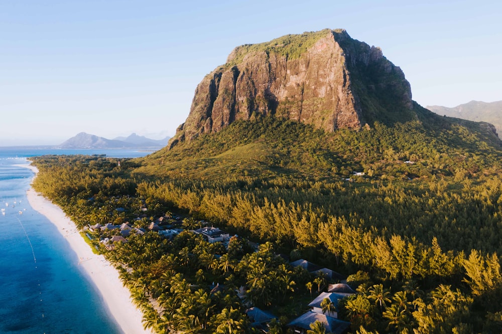 an aerial view of a beach with a mountain in the background