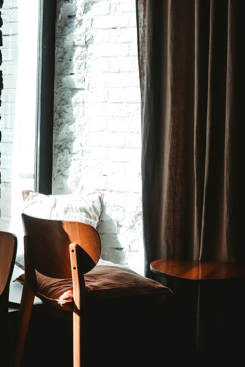 brown wooden table near brown window curtain