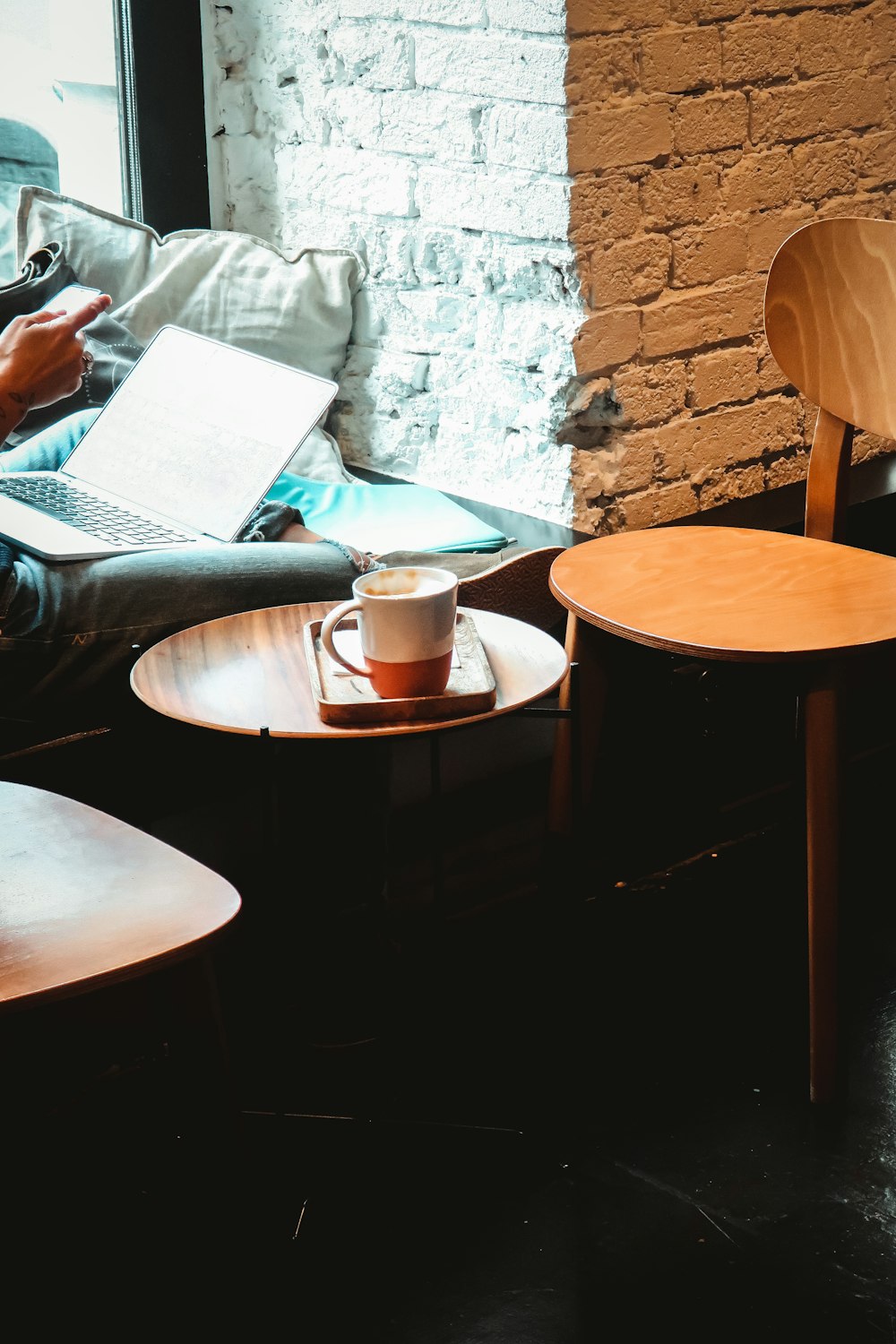 white ceramic mug on brown wooden round table