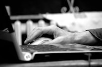 Close-up of a hand using AI-powered software on a laptop for contract management.