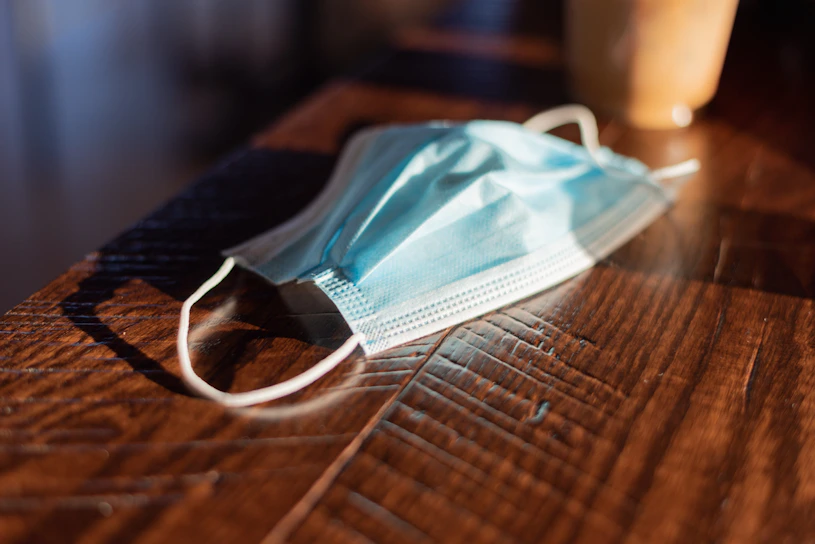 Close-up of a soft, breathable aerisana mask resting gently on a wooden table with natural light highlighting its texture.