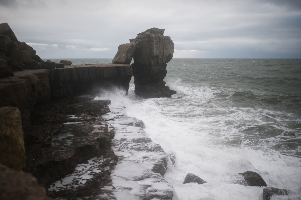 brown rock formation on sea water during daytime