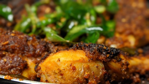 A close-up shot of crispy fried chicken with golden crust and herbs.