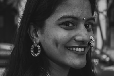Close-up image of a confident woman wearing delicate bijoux, smiling warmly.