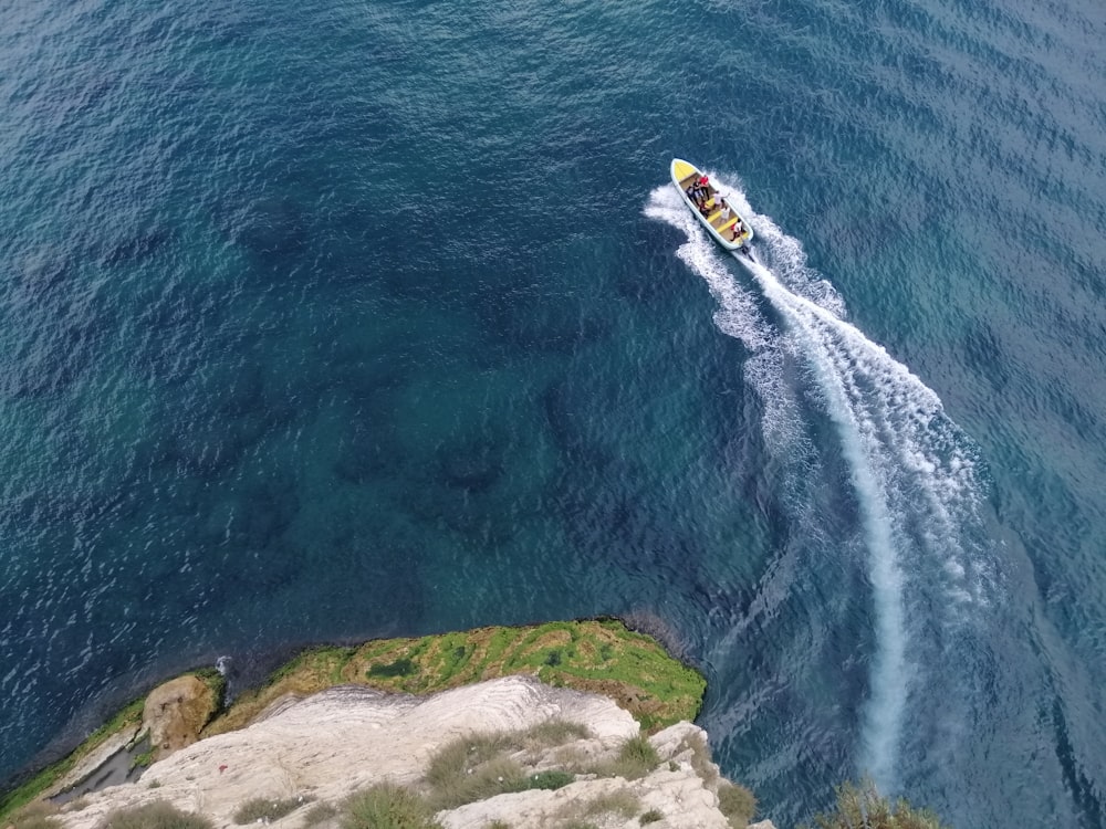 white and yellow boat on blue sea during daytime