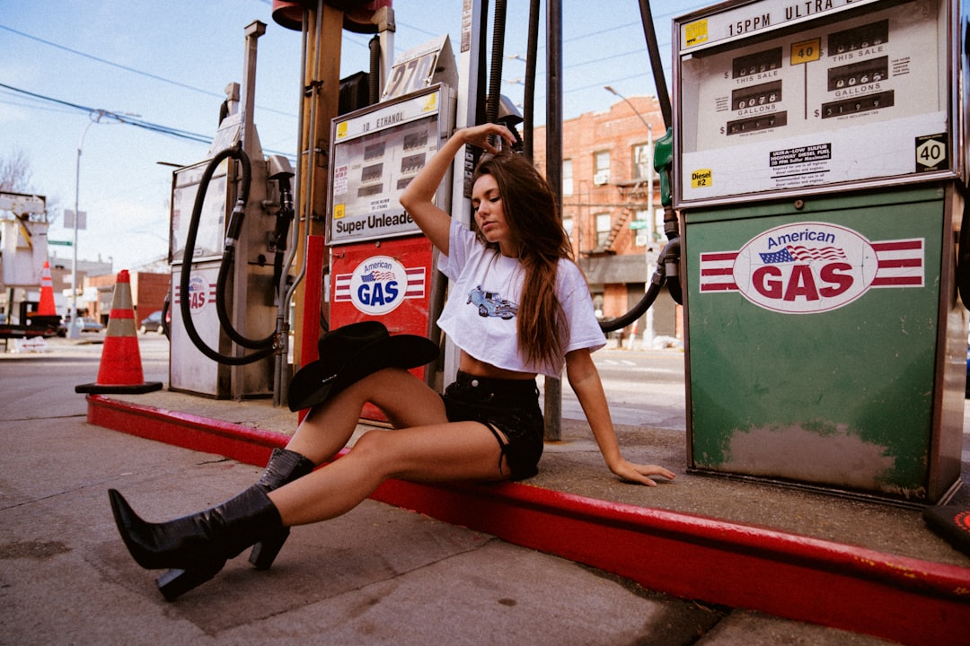 woman in white shirt and black shorts sitting on red bench