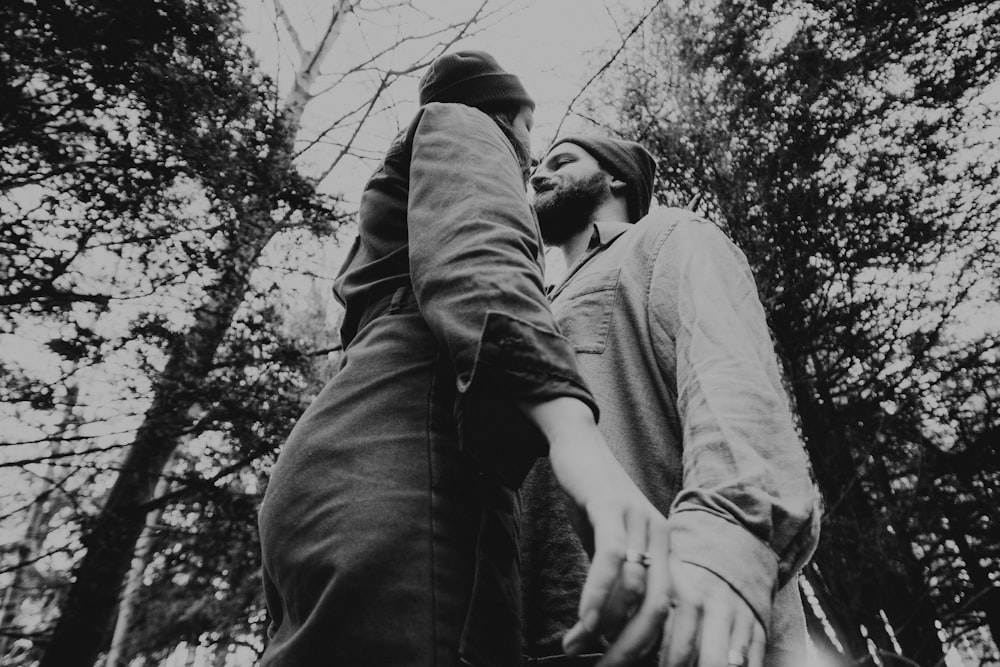 man and woman kissing under tree