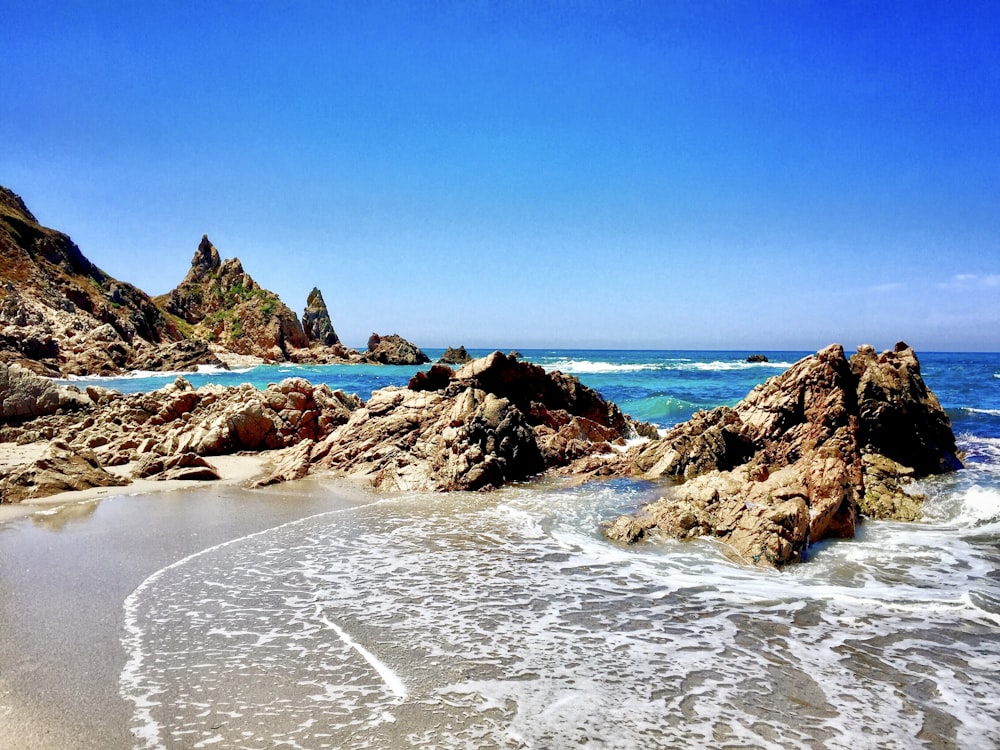 brown rock formation on sea shore during daytime