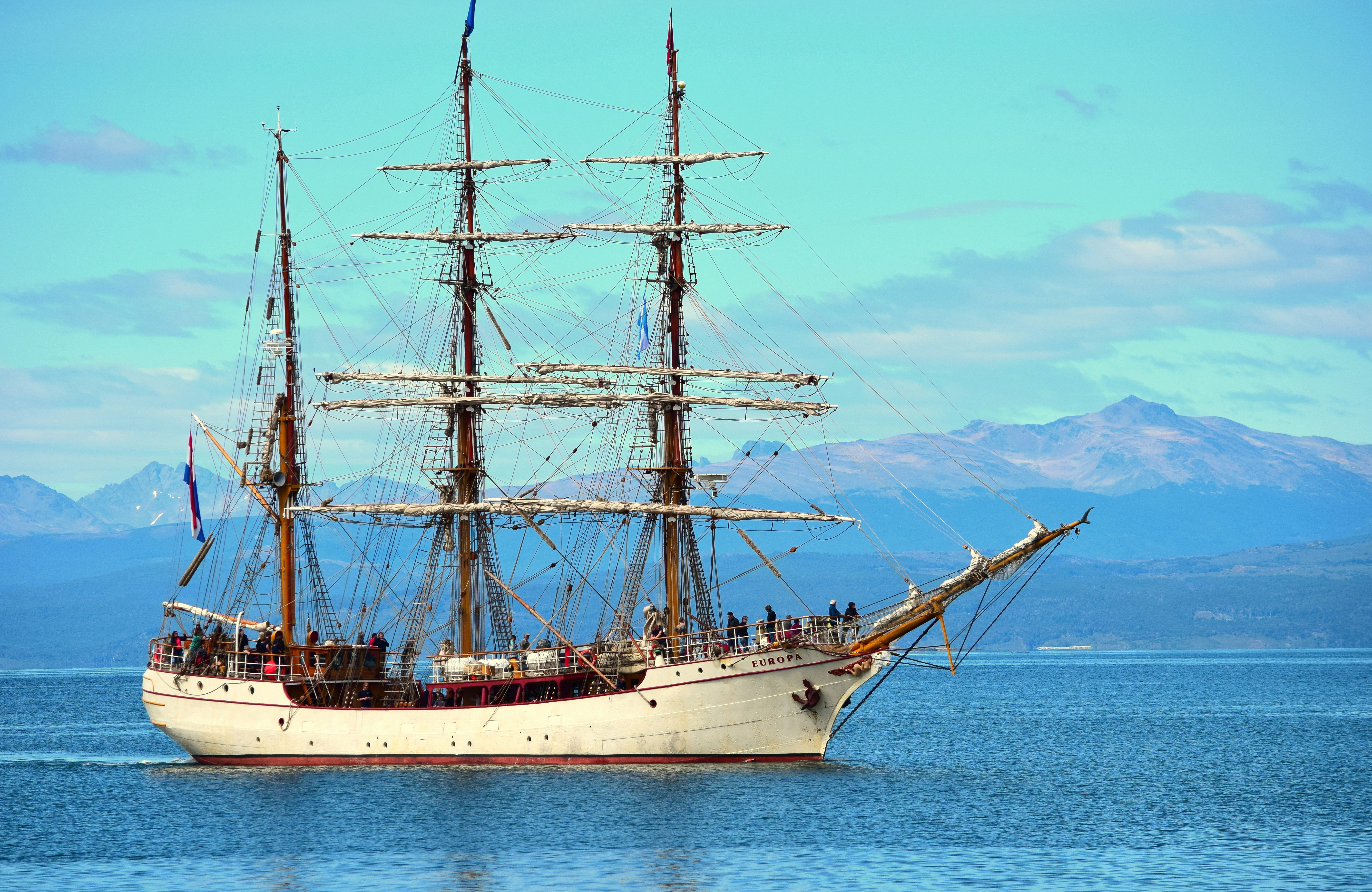 white and brown ship on sea under blue sky during daytime