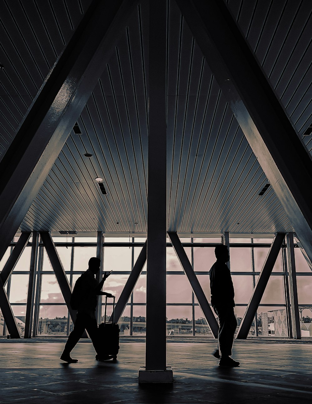 silhouette of 2 person walking on a building