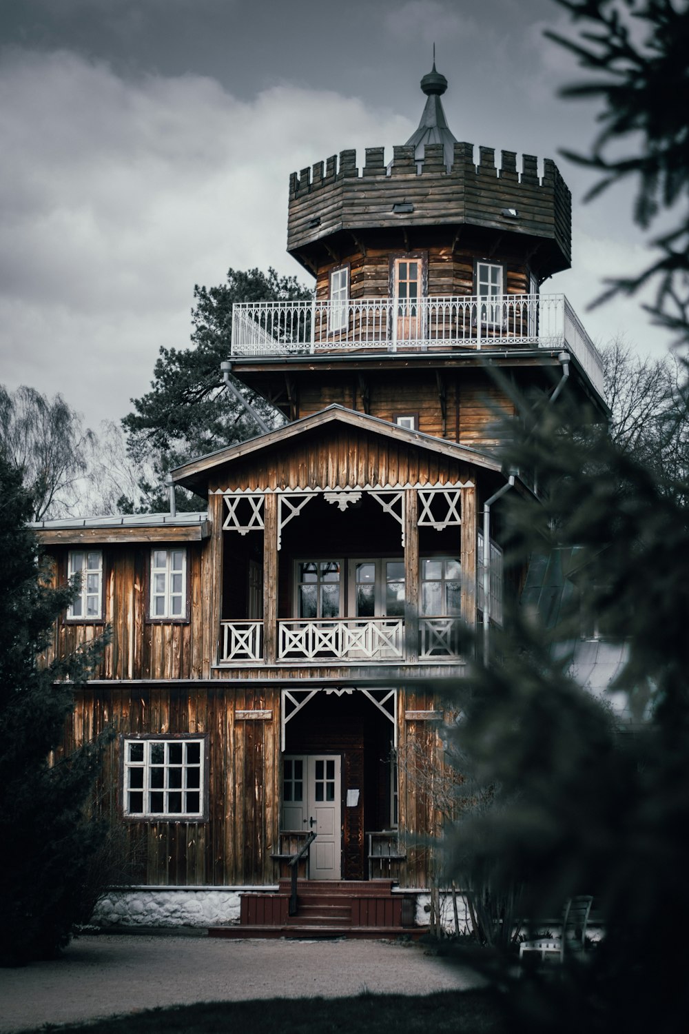 casa di legno marrone e bianca circondata da alberi