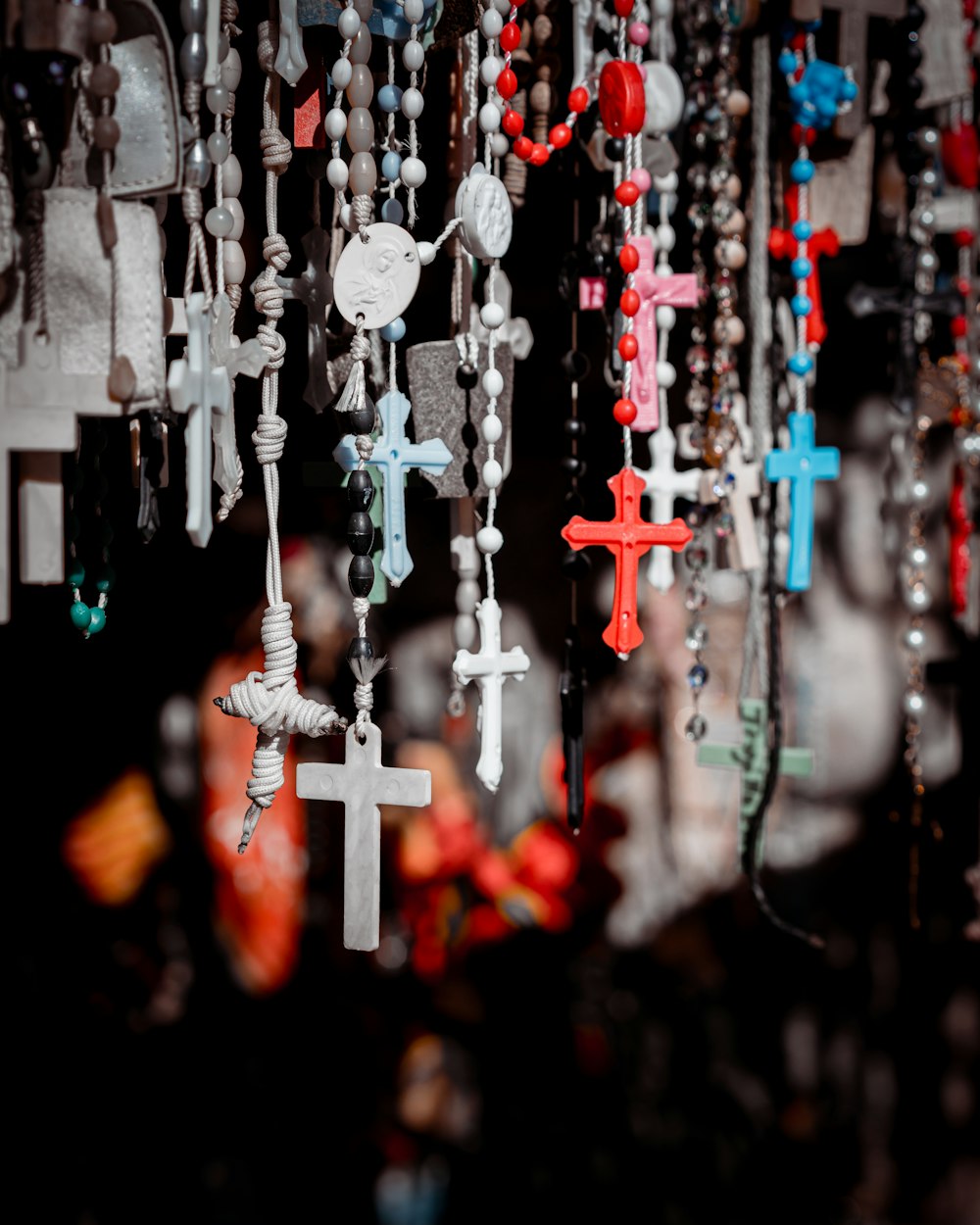 white and red cross hanging on black string