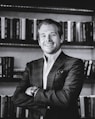 man in black suit jacket smiling