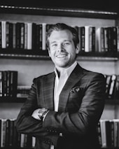 man in black suit jacket smiling