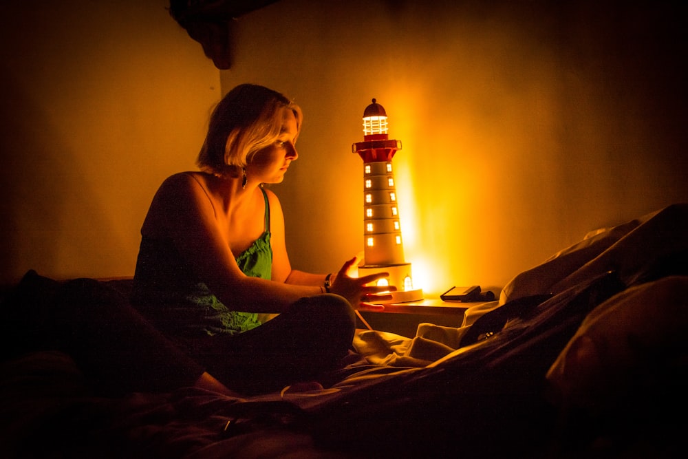 woman in red tank top sitting on bed