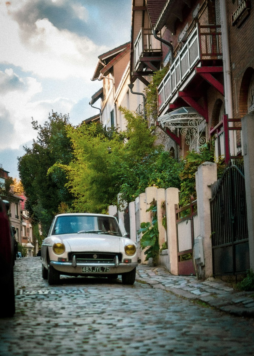 silver car parked beside red and white concrete building during daytime