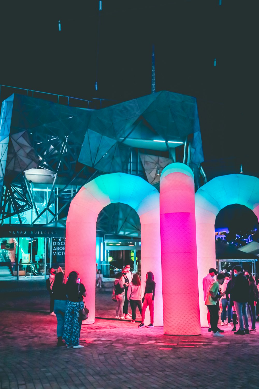 people standing near pink lighted building during night time