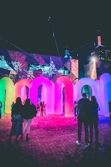 man and woman standing near purple lighted building