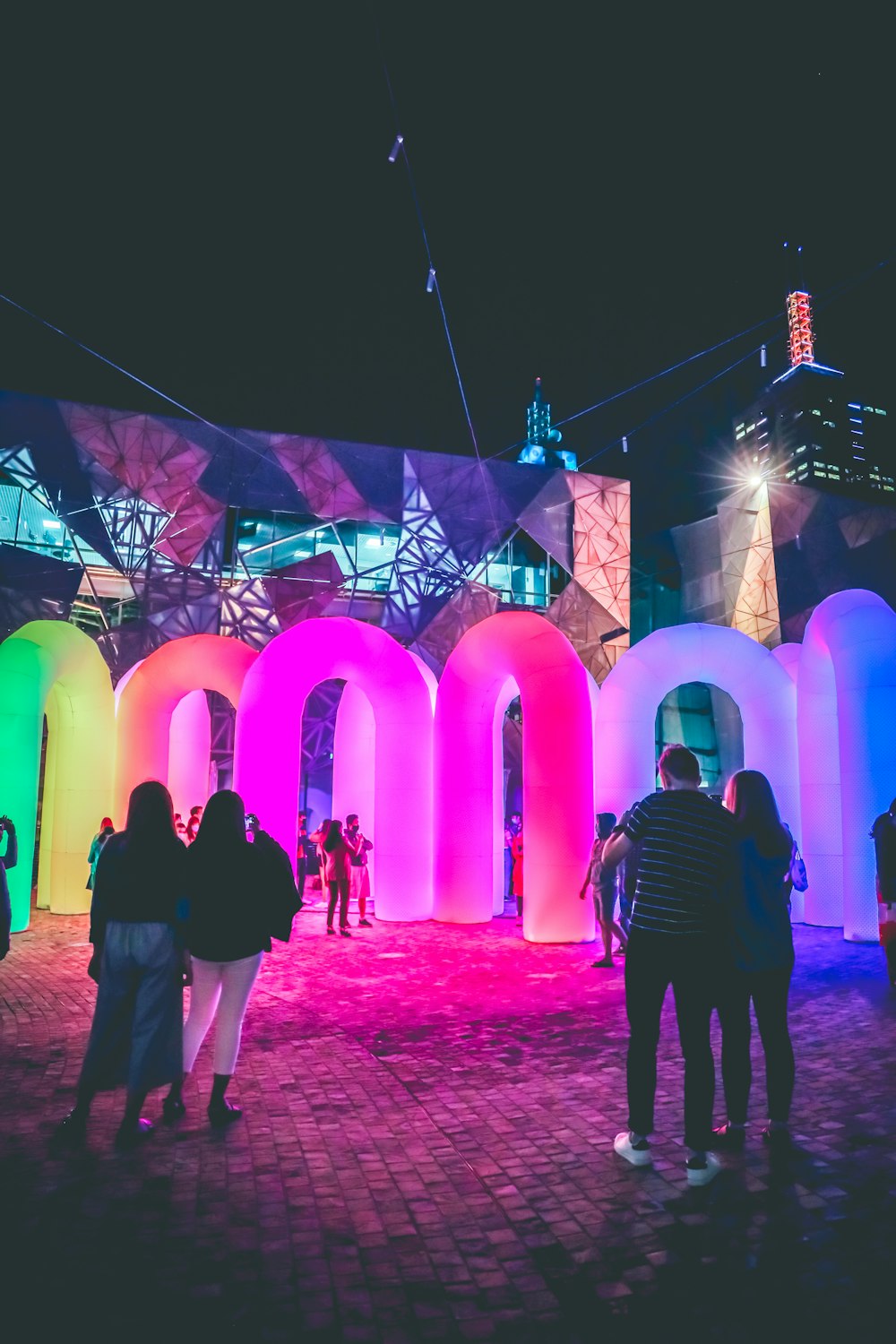 man and woman standing near purple lighted building