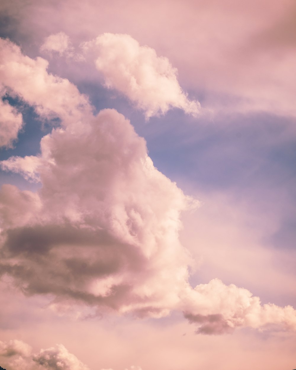 a plane flying through a cloudy blue sky