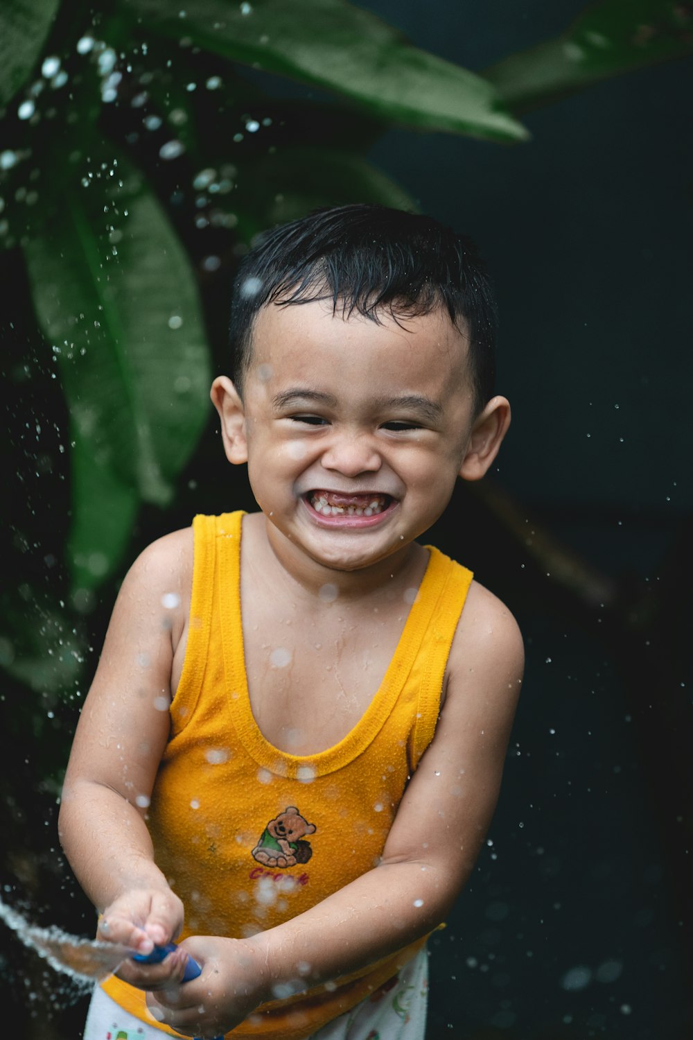 boy in yellow tank top smiling