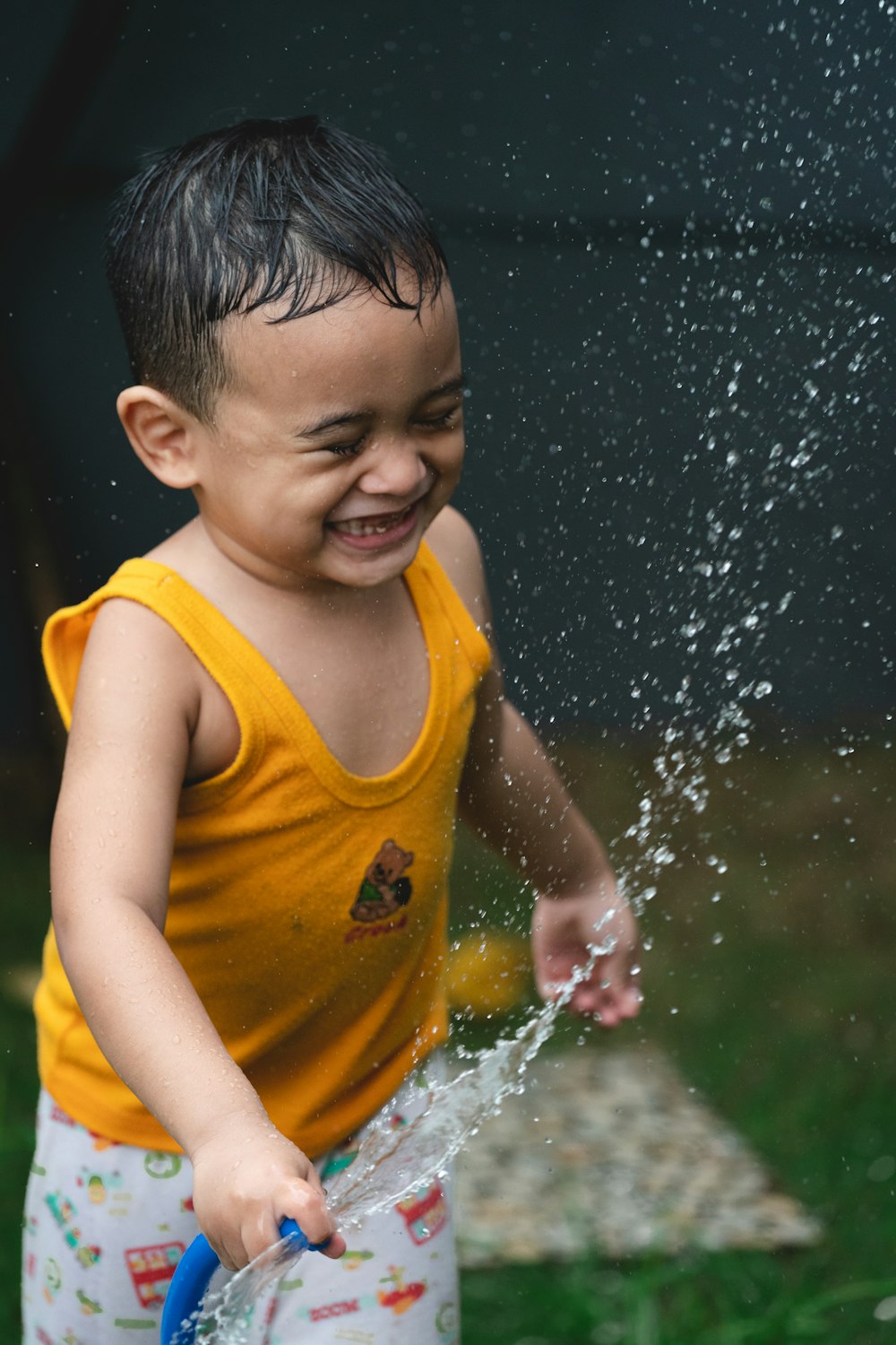 boy in yellow tank top on water