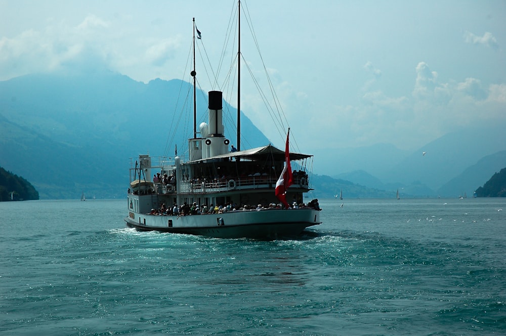 white and red ship on sea under blue sky during daytime