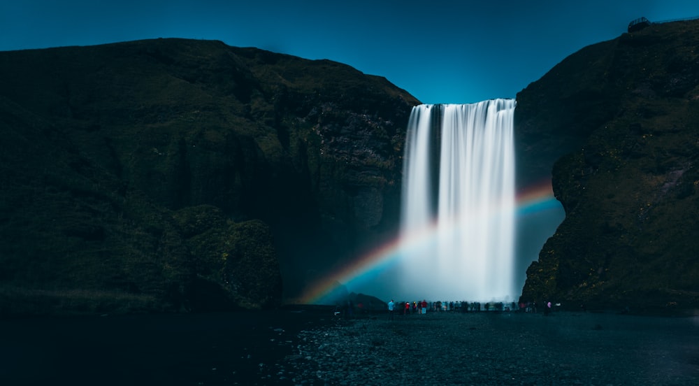 people standing near waterfalls during daytime