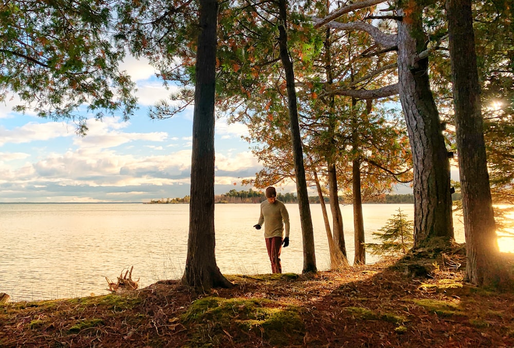 man in gray hoodie standing near body of water during daytime