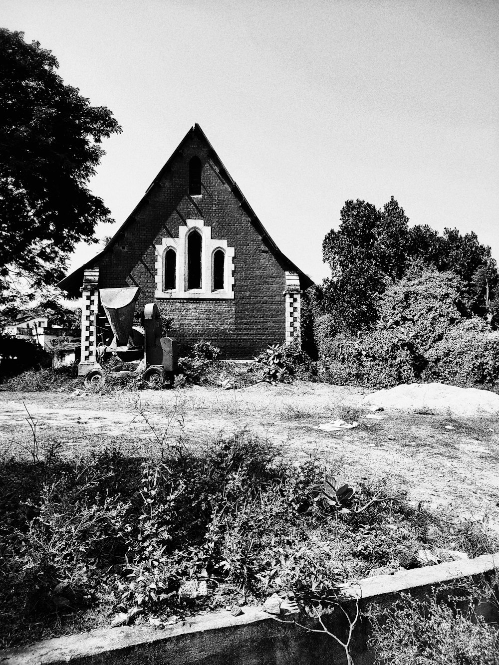 grayscale photo of a house near trees