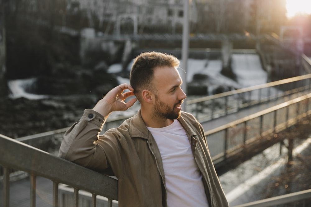 man in gray zip up jacket sitting on black wooden bench