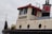 A close-up view of the upper part of a tugboat with a sign labeled 'BARNHOUSE'. The structure features a cream-colored exterior with red and black accents. There is a large window on the side, a ladder, and round portholes.