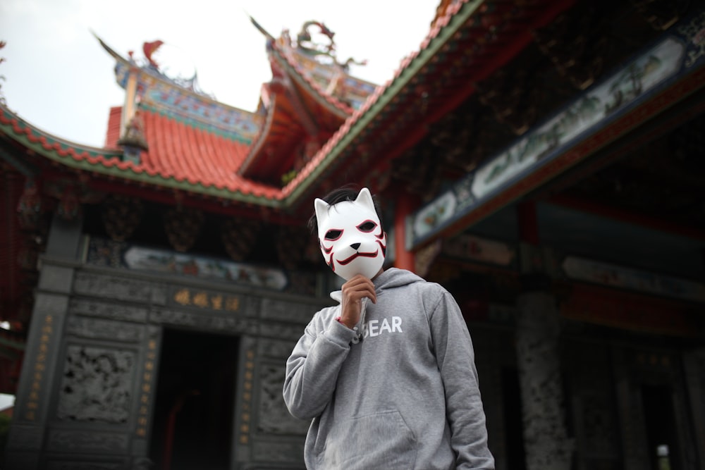 person in gray hoodie wearing white mask