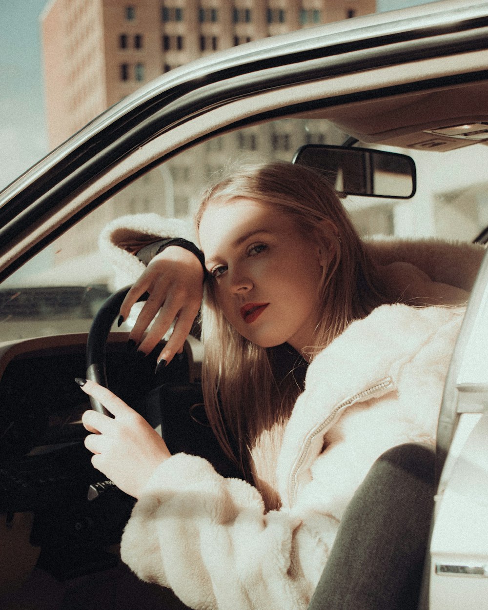 woman in white coat sitting inside car