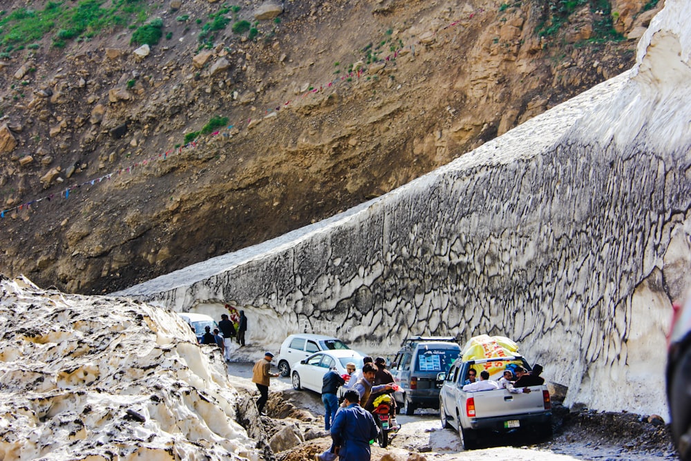 people sitting on gray rock formation during daytime